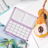 Fuumuui Art Supplies Mini palette de mélange d'aquarelle, violette, avec 24 godets et plateaux de mélange doubles pour la peinture portable, affichée ouverte avec des œuvres d'art à l'aquarelle.
