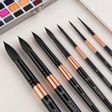 Fuumuui Set di 7 pennelli professionali in martora per acquerello con manici neri, ghiere in rame e varie dimensioni, disposti con una tavolozza di pittura ad acquerello.