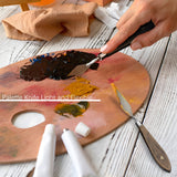 Fuumuui professional artist using a flexible palette knife from an oil paint brush set to mix acrylic paints on a wooden palette for canvas painting.