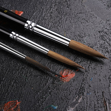 Fuumuui & Svetlin Sofroniev Master's Set Ultimate Collection professionelle Künstlerfarbenpinsel mit drei runden Pinseln mit natürlichen braunen Borsten, silbernen Zwingen und schwarzen Griffen auf einer dunklen, strukturierten Oberfläche.