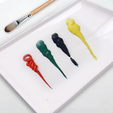 Palette de plateau en céramique Fuumuui pour mélanger les peintures, avec des touches de peinture rouge, verte, noire et jaune vibrantes et un pinceau d'artiste.