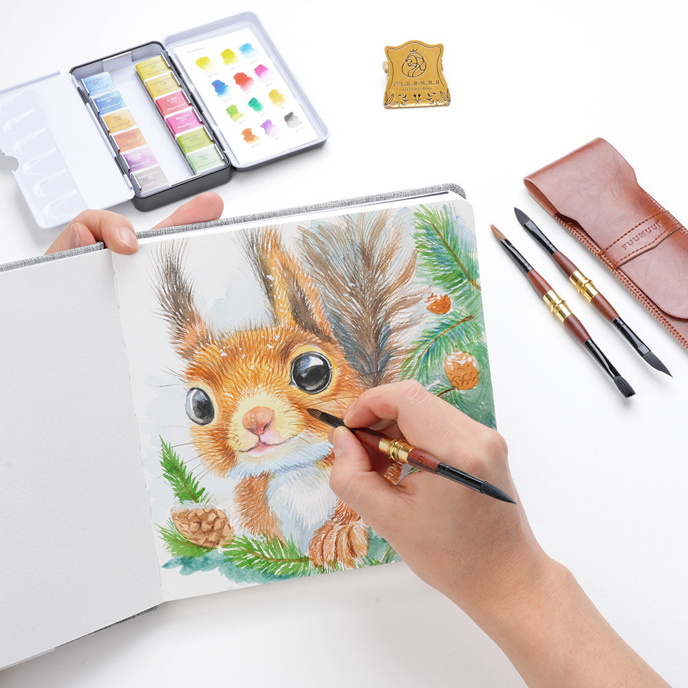 Professional artist painting a squirrel in a cold press watercolor sketchbook using a travel watercolor brush. Includes a watercolor paint set, squirrel hair brushes, and a leather travel brush case.