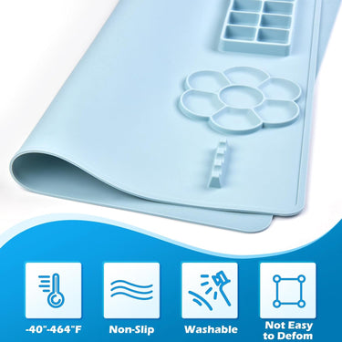 Fuumuui light blue silicone painting mat with integrated multi-well flower palette, rectangular paint mixing cups, and brush holder, emphasizing its non-slip, washable, and durable design.