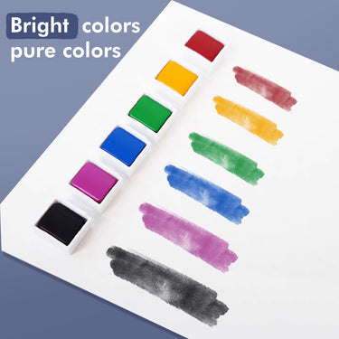 Set di colori ad acquerello Fuumuui da 48 colori che mostra vivaci cialde individuali di acquerello rosse, gialle, verdi, blu, magenta e nere con le corrispondenti campioni di colore puro su carta bianca.