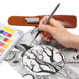 Fuumuui Set di 3 pennelli da viaggio in nylon per acquerello. Una mano dipinge dettagli intricati con un pennello da viaggio per acquerello Fuumuui, accanto a una tavolozza di acquerelli colorata e alla custodia protettiva in pelle del set di pennelli.