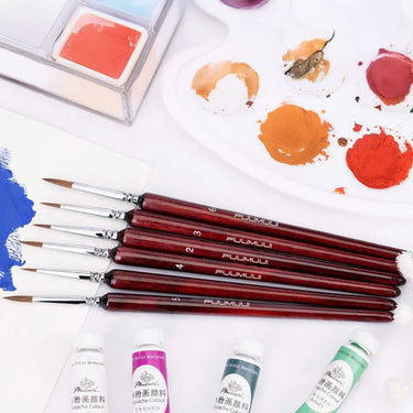 Fuumuui 6-teiliges professionelles Detailpinsel-Set mit verschiedenen Spitzengrößen, das neben einer Malerpalette und Gouache-Farben ausgestellt ist.