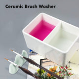 Fuumuui Keramik-Pinselwaschschüssel: Doppelkammer-Pinselreiniger für Künstler, mit rosa und klarem Wasser und feinen Kunstpinseln.