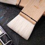 A close-up of a Fuumuui 40mm wool watercolor brush, featuring extra soft, high absorption bristles and a natural bamboo handle, perfect for washes, backgrounds, and large area painting.