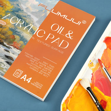 Blocs de peinture acrylique et à l'huile Fuumuui A4 - 20 feuilles, adaptés aux étudiants, débutants, peintres professionnels, avec une surface de papier texturée de 350 g/m² et un carton de support épais, présentés avec des peintures jaune et orange vives sur une palette d'artiste et deux pinceaux.