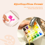 Fuumuui Art Supplies: Tavolozza in ceramica a 20 pozzetti che dimostra una pulizia senza sforzo. Una mano pulisce la vernice dal vassoio di miscelazione in porcellana antimacchia, mentre un'altra tavolozza viene sciacquata sotto un rubinetto, ideale per gli artisti.