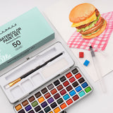 Forniture artistiche Fuumuui Set di acquerelli portatile a 50 colori con pennelli e spugne aperto, che mostra colori vivaci e strumenti per la creazione artistica versatile sempre e ovunque.