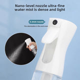 Vaporisateur haute pression Fuumuui, blanc et transparent, avec une main démontrant sa buse de niveau nano de 0,3 mm pulvérisant une brume d'eau ultra-fine et dense.
