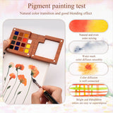 Set di acquerelli in legno premium Fuumuui con 15 colori selezionati a mano e tavolozza di miscelazione integrata, dimostrato da un artista che dipinge fiori vivaci e campioni di test di pigmenti che mostrano miscelazione uniforme, diffusione e forniture artistiche trasparenti Fuumuui.