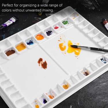 Palette d'aquarelle professionnelle Fuumuui à 47 godets, organisateur de fournitures d'art en plastique antiadhésif blanc rempli de peintures vibrantes, avec une zone de mélange centrale et un porte-pinceau.