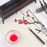 Fuumuui tragbarer Pinsel mit Wieselhaaren für Reisekalligraphie, der das Malen von roten Pflaumenblüten und Bambus mit roter Tinte und Fuumuui-Kunstbedarf zeigt.