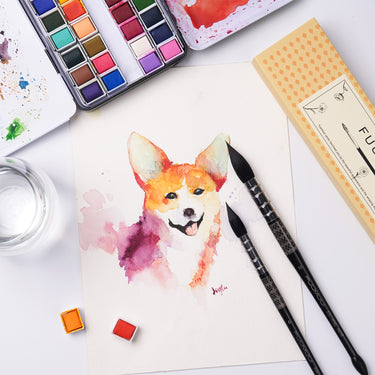 Pinceaux aquarelle professionnels Fuumuui avec corps imprimés détaillés reposant sur une peinture de corgi vibrante, accompagnés de fournitures d'art Fuumuui et de peintures aquarelles.