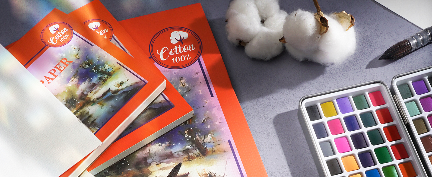 100% Cotton Watercolor Paper pads and sketchbook displayed with a professional watercolor paint set and a squirrel hair watercolor brush. Premium art supplies for professional artists and beginners.