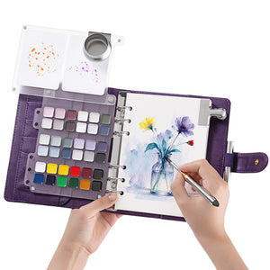 Fuumuui 36-color semi-solid watercolor travel sketchbook purple large open with palette plate while painting flowers.