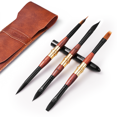 Fournitures d'art Fuumuui : Ensemble de 3 pinceaux aquarelle de voyage synthétiques à double pointe avec d'élégants manches en bois foncé, des viroles dorées et diverses formes de pinceaux synthétiques (rond, dague, plat), présentés à côté de sa pochette en cuir marron, parfaits pour l'aquarelle et la gouache.