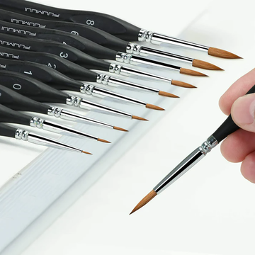 Ensemble de 10 pinceaux de détail professionnels en martre Fuumuui, avec un pinceau tenu à la main, mettant en valeur les pointes fines pour des œuvres d'art complexes.