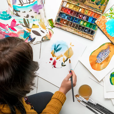 Artista che crea un dipinto ad acquerello con un pennello professionale per acquerello in martora Fuumuui, circondato dal set di 8 pennelli professionali per acquerello in martora Fuumuui e da una tavolozza colorata.