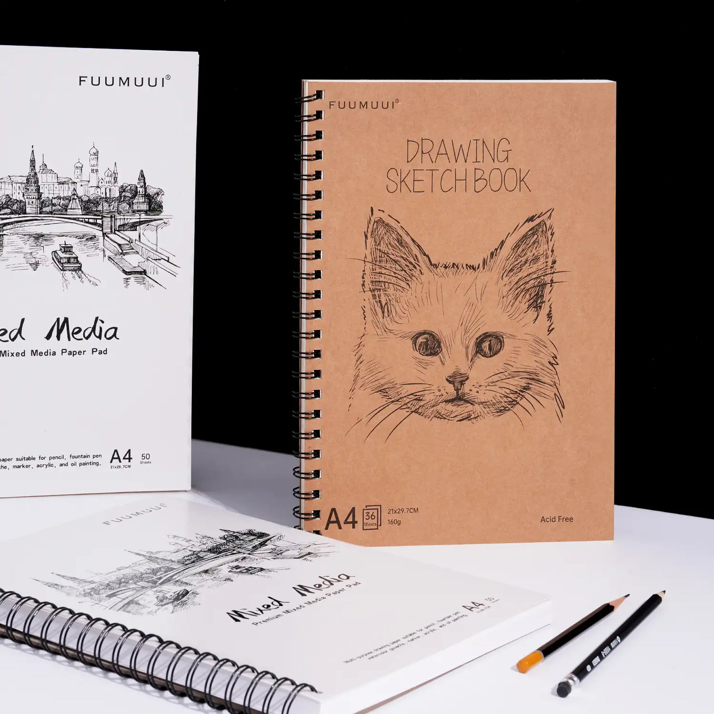 Fuumuui A4 Drawing Sketchbook with 160g acid-free paper and cat illustration, shown alongside a spiral bound Mixed Media Paper Pad and pencils. Premium sketching paper for professional artists and beginners.