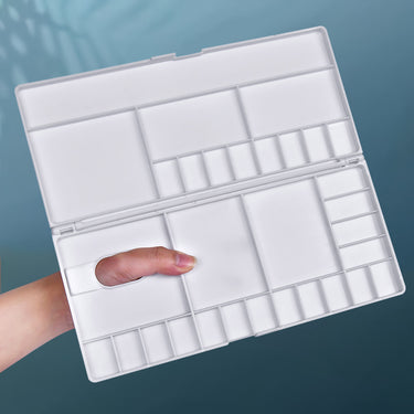 Fuumuui Plastikfarbpalette mit geöffnetem Deckel, mit mehreren Mischmulden und einem Daumenlochgriff für die Aquarellmalerei.